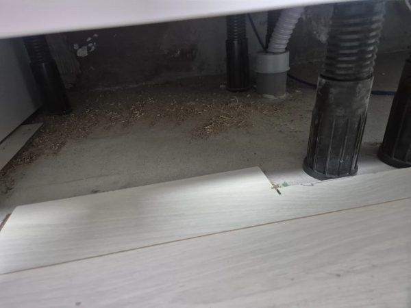 가전제품 하부 틈새 먼지를 살펴보는 모습